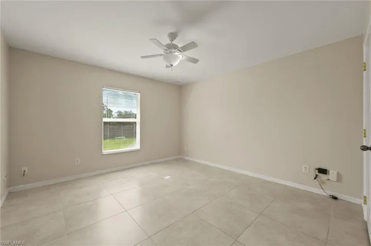Unfurnished room featuring a ceiling fan and light tile patterned floors
