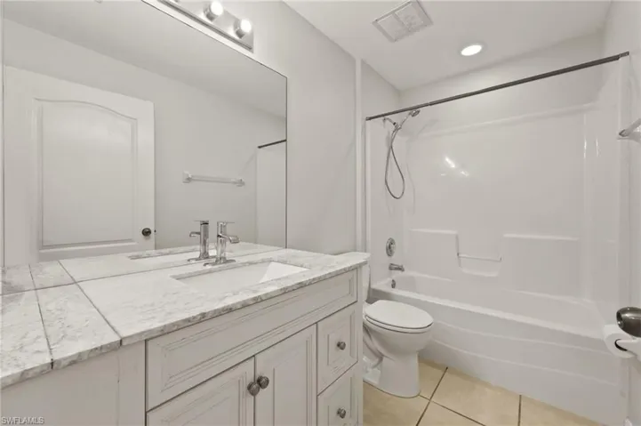 Bathroom featuring vanity, tile patterned flooring, and shower / bath combination
