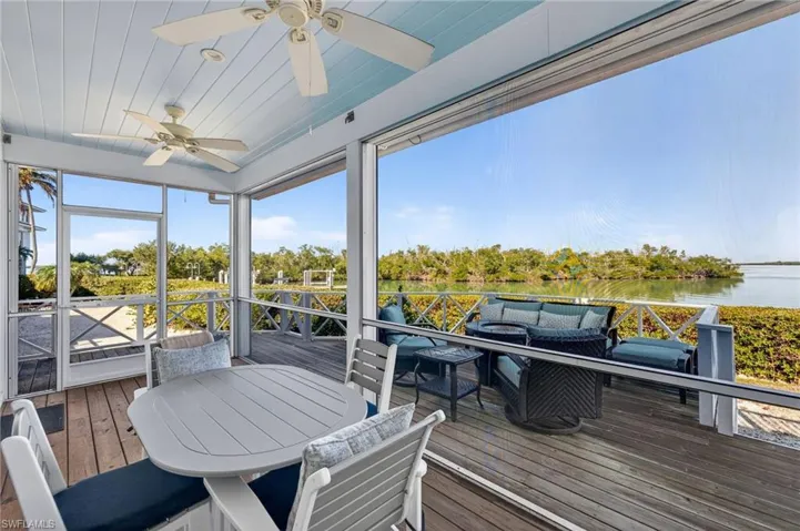 Sunroom featuring an outdoor living space, a deck with water view, ceiling fan, and outdoor dining space