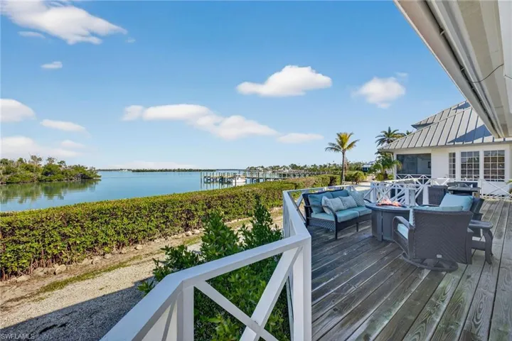 Deck with a water view and an outdoor living space with a fire pit