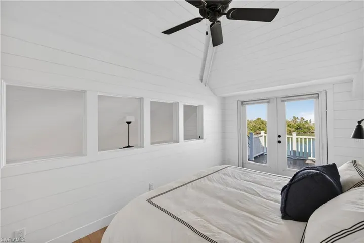 2nd floor Bedroom featuring wood walls, access to outside, french doors, ceiling fan, and wood finished floors