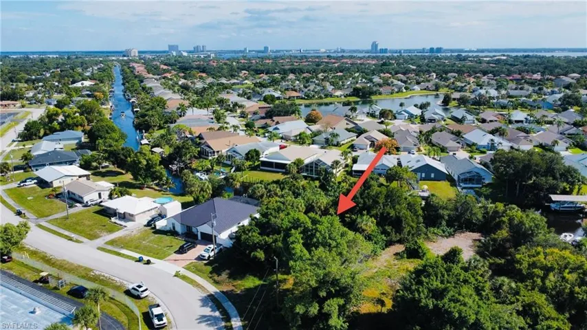 Aerial view of property and surrounding area with nearby suburban area and a nearby body of water