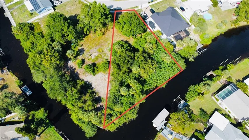 Aerial perspective of suburban area featuring a nearby body of water and property boundaries highlighted