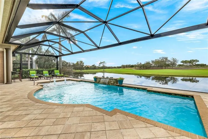 View of swimming pool with a water view, pool water feature, a patio area, and a lanai