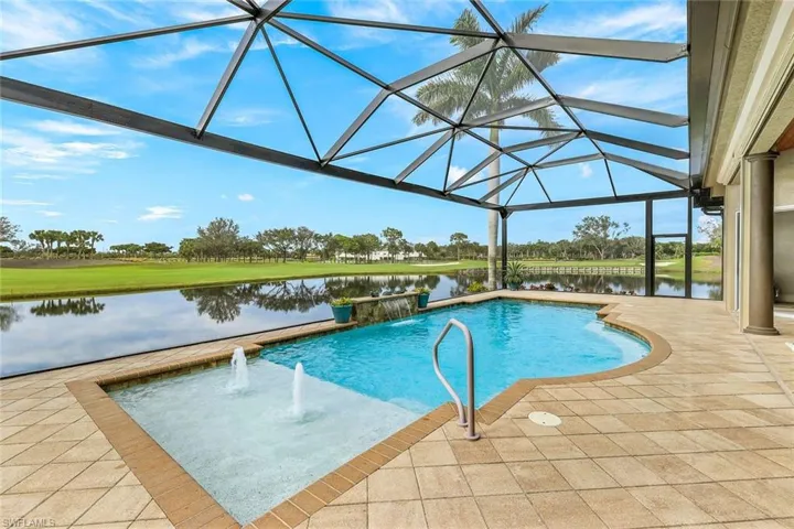 View of pool featuring a patio area, a water view, pool water feature, and a lanai