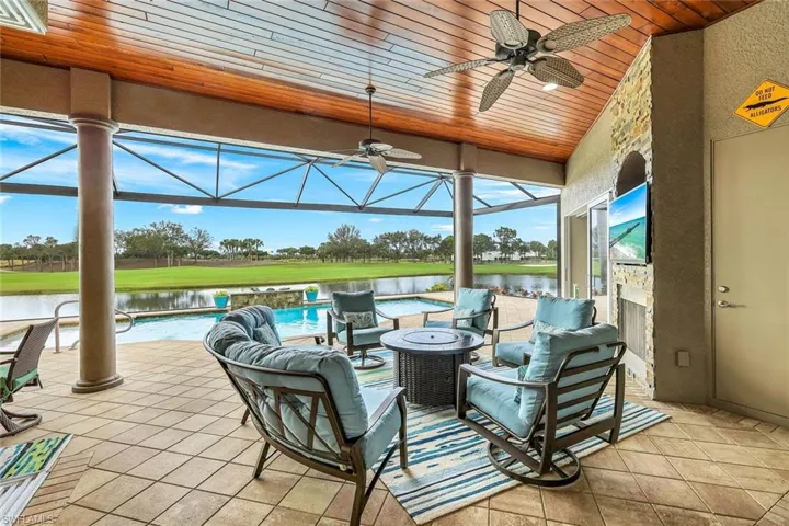 Sunroom / solarium with ceiling fan, a water view, and wooden ceiling