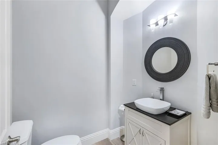Bathroom with hardwood / wood-style floors, toilet, and vanity