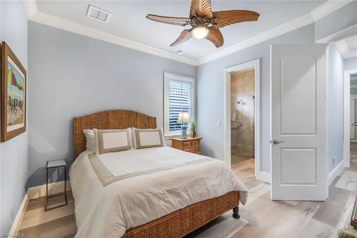 Bedroom with crown molding, ceiling fan, and light hardwood / wood-style floors