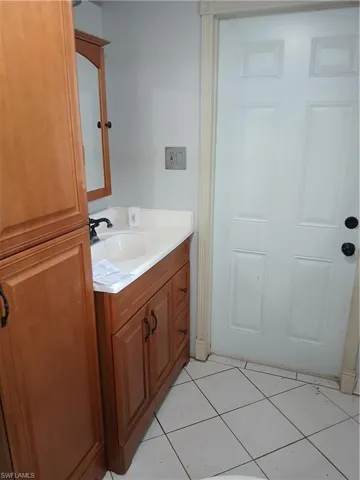 Primary Bathroom with vanity, tile flooring & exit to rear covered porch