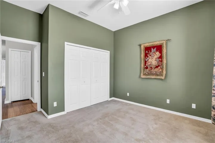 Unfurnished bedroom with a closet, carpet, and ceiling fan