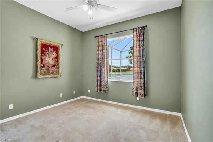 Carpeted spare room featuring ceiling fan