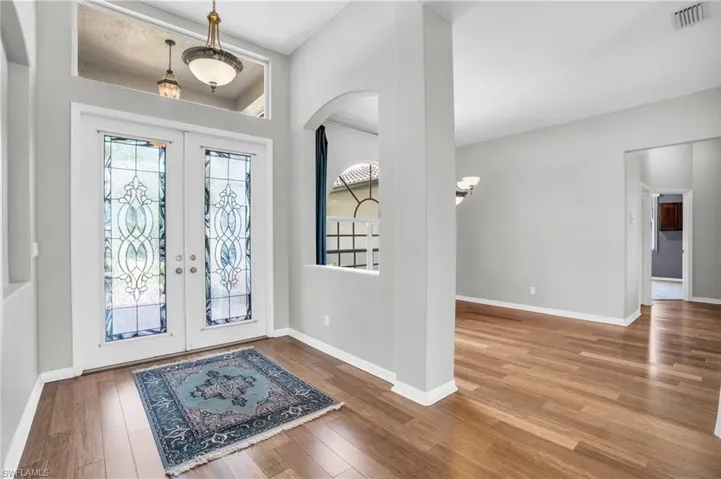 Foyer entrance featuring wood-style floors and glass french doors