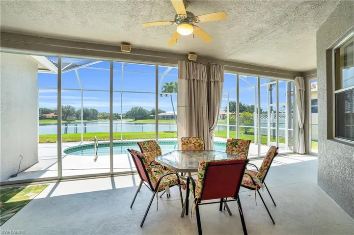Sunroom with ceiling fan, a healthy amount of sunlight, and a water view