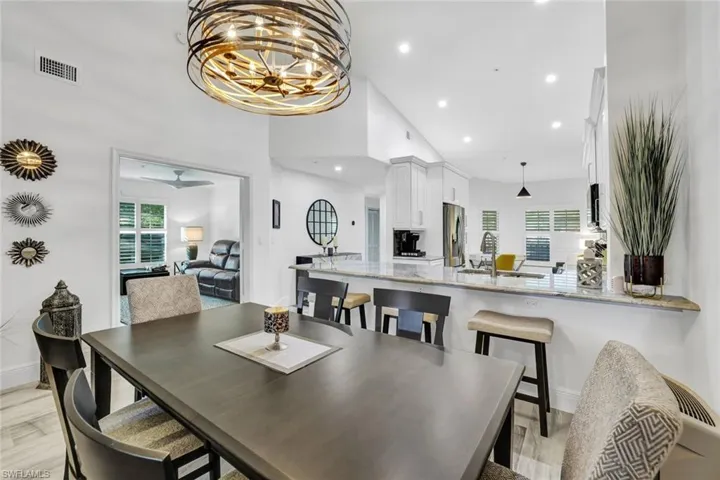 Dining space featuring sink, high vaulted ceiling, and tile that looks like  wood-style floors