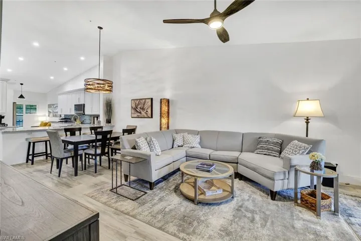 Living room featuring Tile that looks like wood planks  hardwood / wood-style floors, lofted ceiling, and ceiling fan