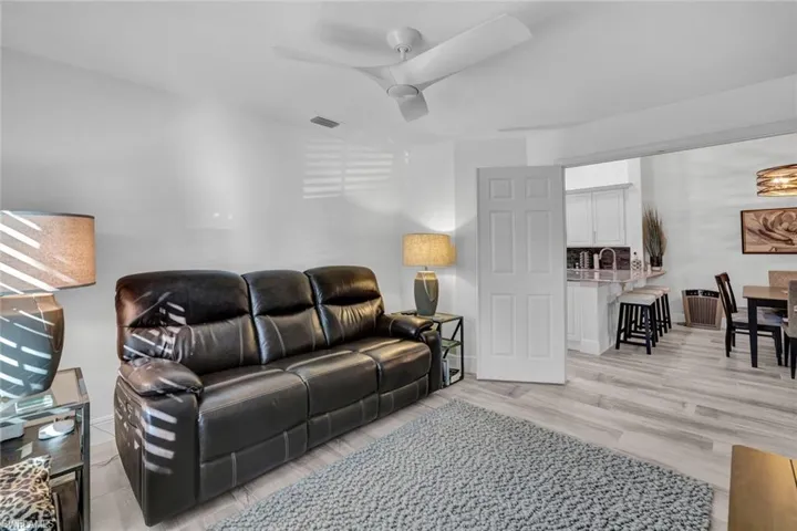 Living room featuring light wood tilee flooring and ceiling fan