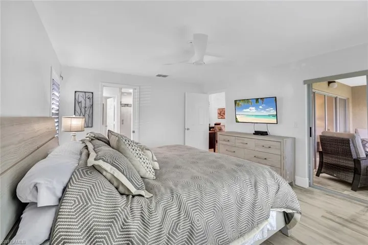Bedroom with ceiling fan and lightTile that looks like wood plank  flooring