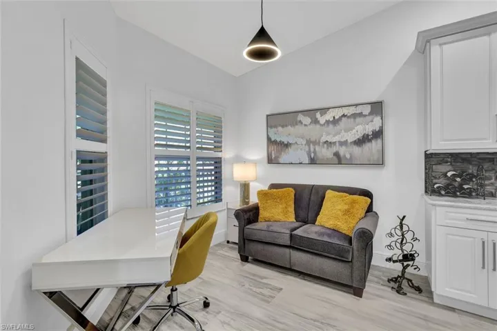 reconfigured breakfast room as Home office with vaulted ceiling and ltile that looks like wood plank  flooring