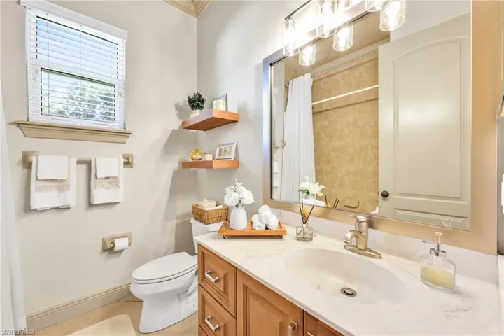 Full bathroom with vanity, a shower with curtain, light tile patterned floors, and ornamental molding