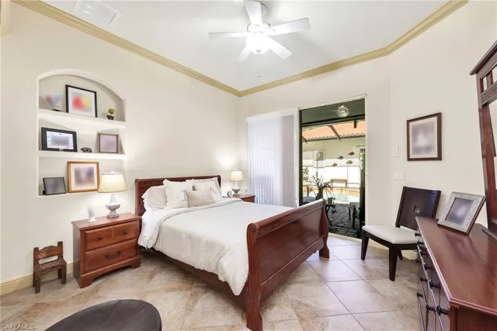 Bedroom with crown molding, ceiling fan, and tile patterned flooring
