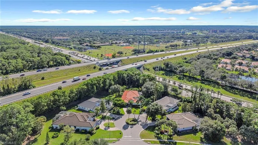 Aerial view of property and surrounding area featuring a main thoroughfare and nearby suburban area