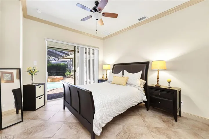 Bedroom featuring ornamental molding, access to outside, ceiling fan, light tile patterned floors, and a sunroom
