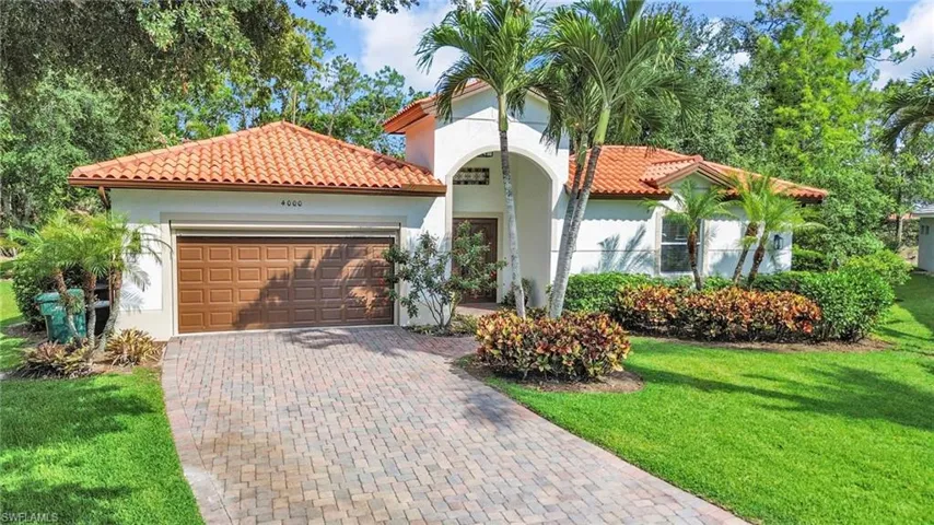 Mediterranean / spanish home with a garage, customize large wood entrance, a front yard, and decorative driveway