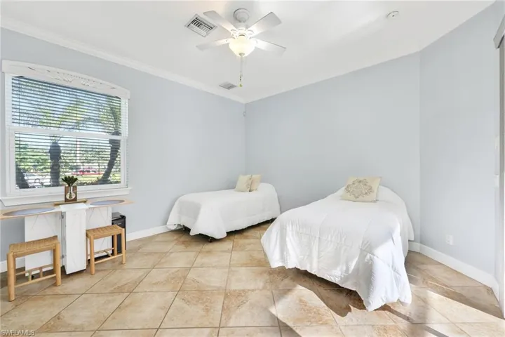 Bedroom featuring crown molding, a ceiling fan, and tile patterned floors