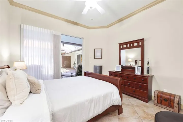 Bedroom with ornamental molding, a ceiling fan, and light tile patterned floors