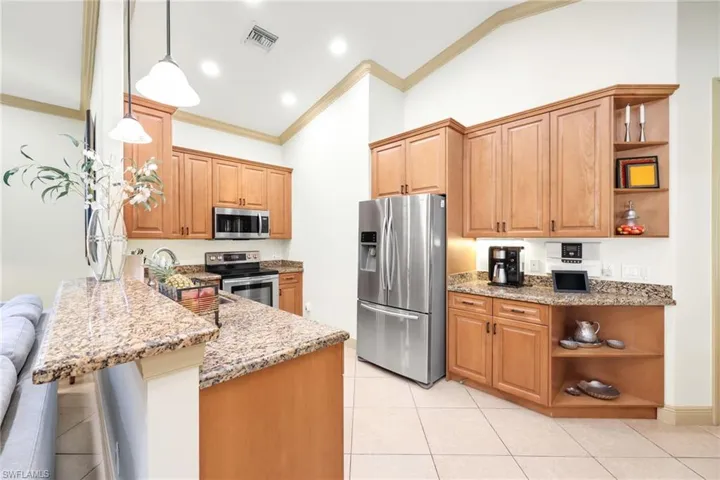 Kitchen featuring open shelves, light stone countertops, appliances with stainless steel finishes, crown molding, and light tile patterned floors