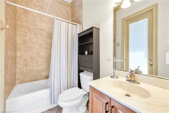 Bathroom with shower / bath combination with curtain and vanity
