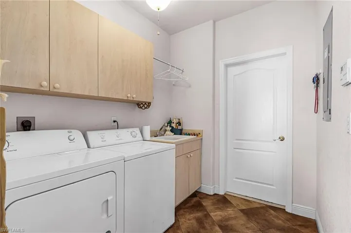 Washroom featuring cabinet space and independent washer and dryer