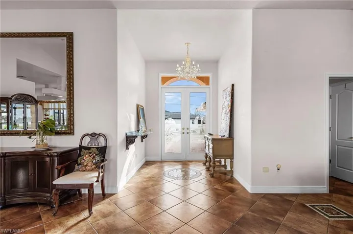 Entryway with french doors, a chandelier, and dark tile patterned flooring