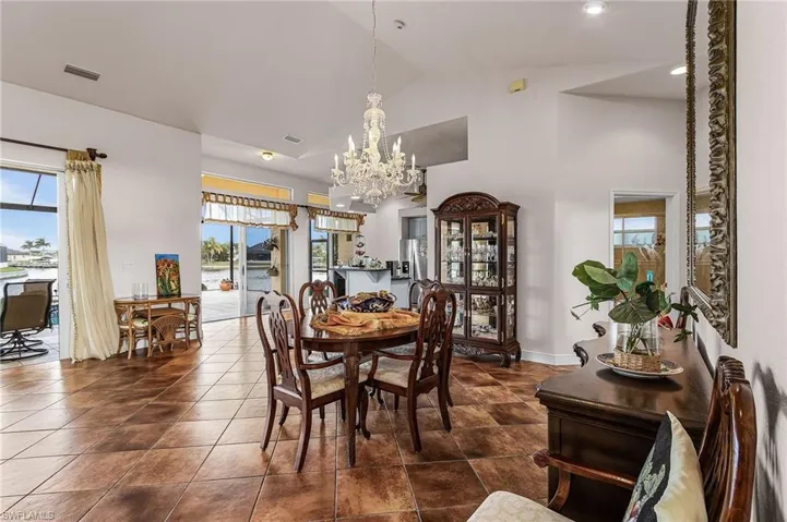Dining space featuring plenty of natural light, a chandelier, high vaulted ceiling, and a water view