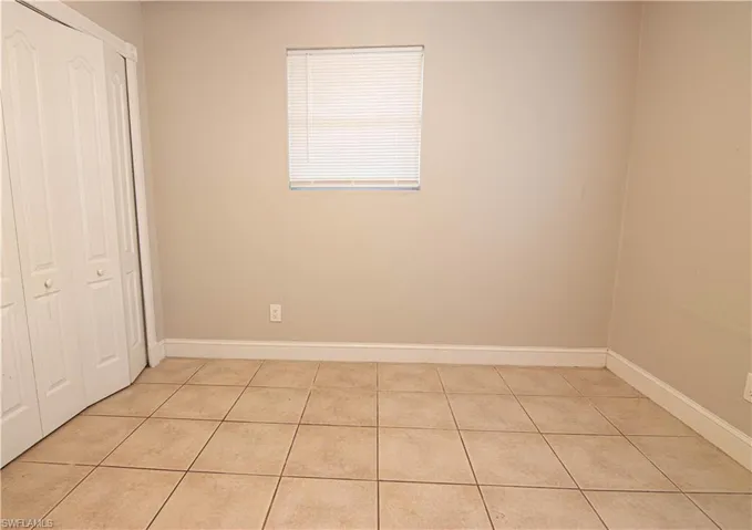 Unfurnished bedroom with light tile patterned flooring and a closet