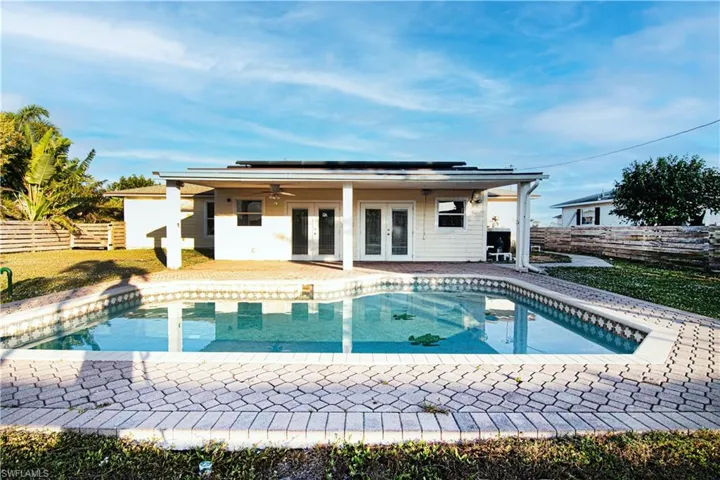 Outdoor pool with a fenced backyard, french doors, and a patio