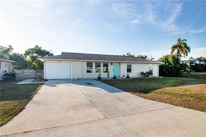 Single story home featuring driveway, a front yard, and a garage