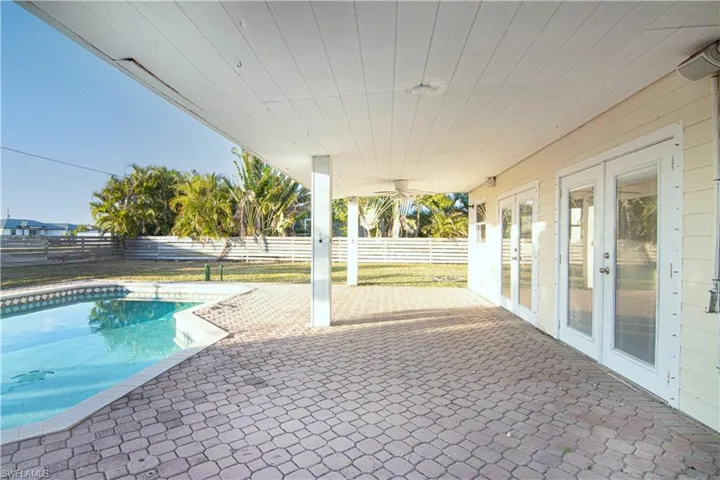 View of pool featuring a patio area, a fenced backyard, and french doors