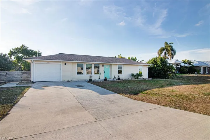 Ranch-style house with concrete driveway, a front lawn, and a garage