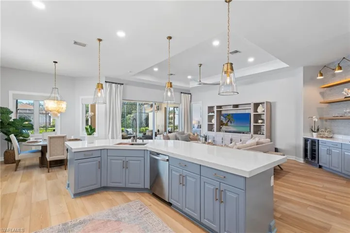 Center Island with sink, light blue cabinets, beverage cooler, stainless steel dishwasher &  raised ceiling