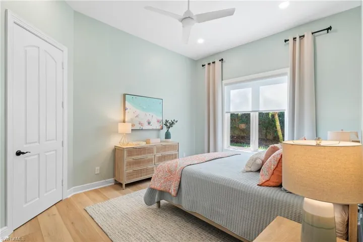 En-Suite Bedroom with ceiling fan & custom blinds and drapery