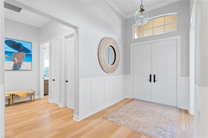 Entrance foyer featuring decorative wall panels & high ceilings with decorative shiplap boards