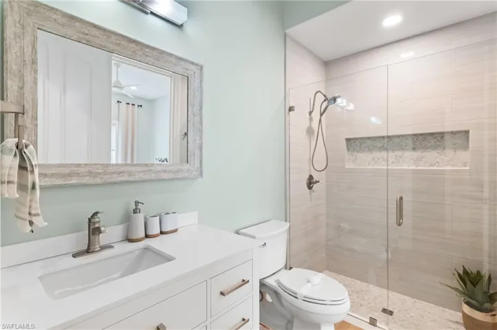 Bathroom with an enclosed shower, decorative tile work and modern vanity