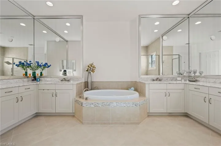 Bathroom featuring vanity, shower with separate bathtub, and tile patterned flooring