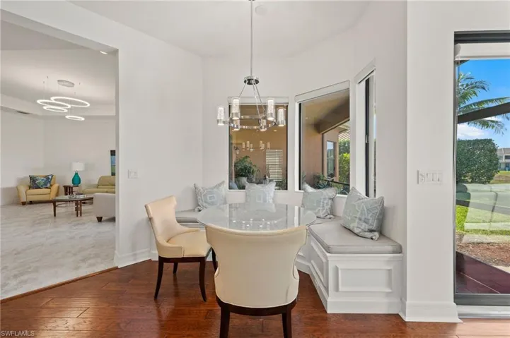 Dining area with dark wood-type flooring and a chandelier