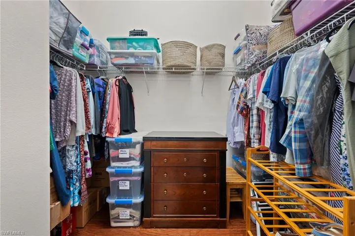 Spacious closet with hardwood / wood-style flooring