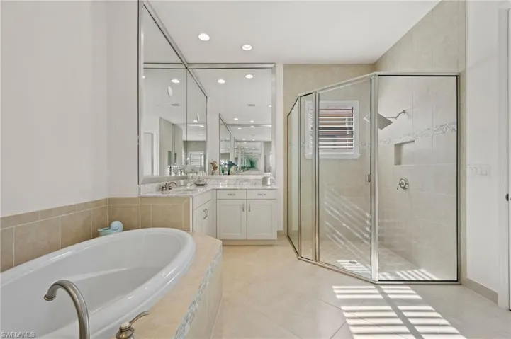 Bathroom with shower with separate bathtub, vanity, and tile patterned floors