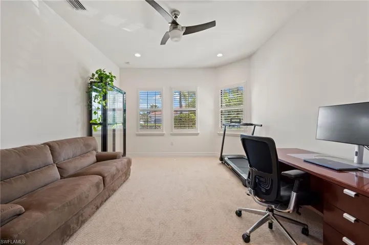 Carpeted office space featuring ceiling fan
