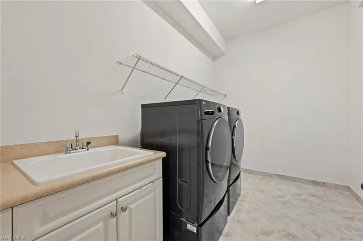 Washroom with cabinets, sink, and independent washer and dryer