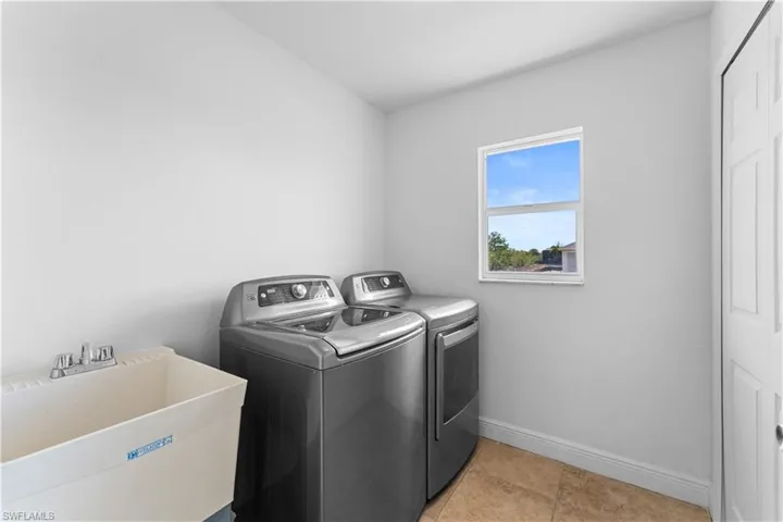 Laundry area with independent washer and dryer and baseboards